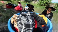 Warga memakai caping untuk menghalau panas matahari.