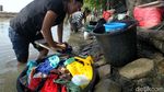 Mencuci Pakaian di Sungai Keruh