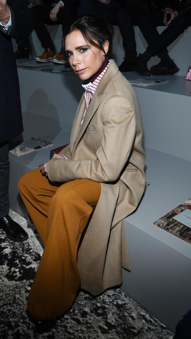 Oversized coat berwarna camel jadi andalan mantan personel Spice Girls ini saat menghadiri fashion show Louis Vuitton di Paris Fashion Week. (Foto: Getty Images)