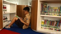 Seorang anak asyik membaca.