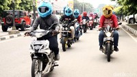 Belasan pengendara sepeda motor konvoi dengan memakai helm elmo.