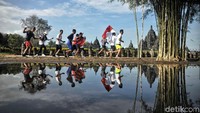 Sebagian peserta berlari sambil mengibarkan bendera merah putih.