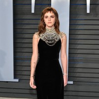 Emma Watson dalam balutan gaun hitam simpel dengan tumpukan kalung silver di after-party Oscar 2018. (Foto: Getty Images)