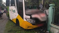 Bus sekolah yang mengangkut rombongan zikir dari Aceh Tamiang menabrak pagar sekolah di Aceh Besar. Akibatnya, dua orang meninggal dunia dan 12 lainnya mengalami luka ringan.   (Foto: Dok. Polres Aceh Besar