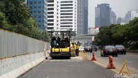 Pekerja melakukan proses penataan ulang jalan dan trotoar di Jalan Sudirman, Jakarta Pusat, Senin (16/4/2018).
