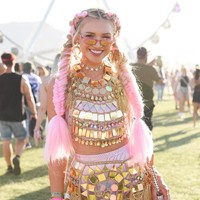 Wanita berambut pink mencuri perhatian memakai crop top dan rok dari lempengan logam. Foto: Dok. Getty Images