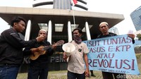 Dalam aksinya, seorang demonstran bernyanyi.