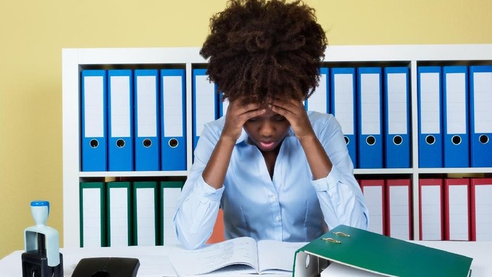 Sad fired crying female secretary. Dismissed office manager woman lying on her workplace desk in desperation