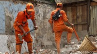 Petugas membersihkan puing-puing bangunan yang dibongkar.