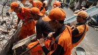 Usai dibongkar, petugas PPSU langsung membersihkan puing-puing bangunan.