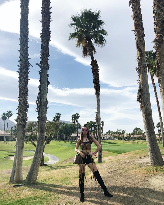 Crop top dengan detail fringe jadi gaya Nia Ramadhani lagi untuk Coachella hari ketiga, Minggu (15/4/2018). Boots hitam melengkapi gaya seksi Nia yang juga kembali melengkapi penampilannya dengan tas dari brand kulit MCM. Foto: Dok. Instagram Nia Ramadhani