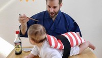  Waduh! Mentang-mentang lagi pakai kostum sushi, sang ayah bergaya layaknya orang yang ingin melahap bayi sushi yang ada dihadapannya. Ada ada aja, ya. Foto: Instagram @accopeko  