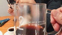 Senyum manis Sherina terlihat jelas dibalik gelas kaca berisi kopi. Hayoo siapa yang memegang gelasnya? Foto: Instagram @sherinasinna