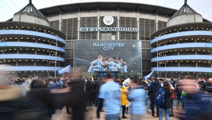 Fans arrive at the Etihad Stadium in Manchester, north west England on April 10, 2018, ahead of the UEFA Champions League second leg quarter-final football match between Manchester City and Liverpool. / AFP PHOTO / Anthony Devlin