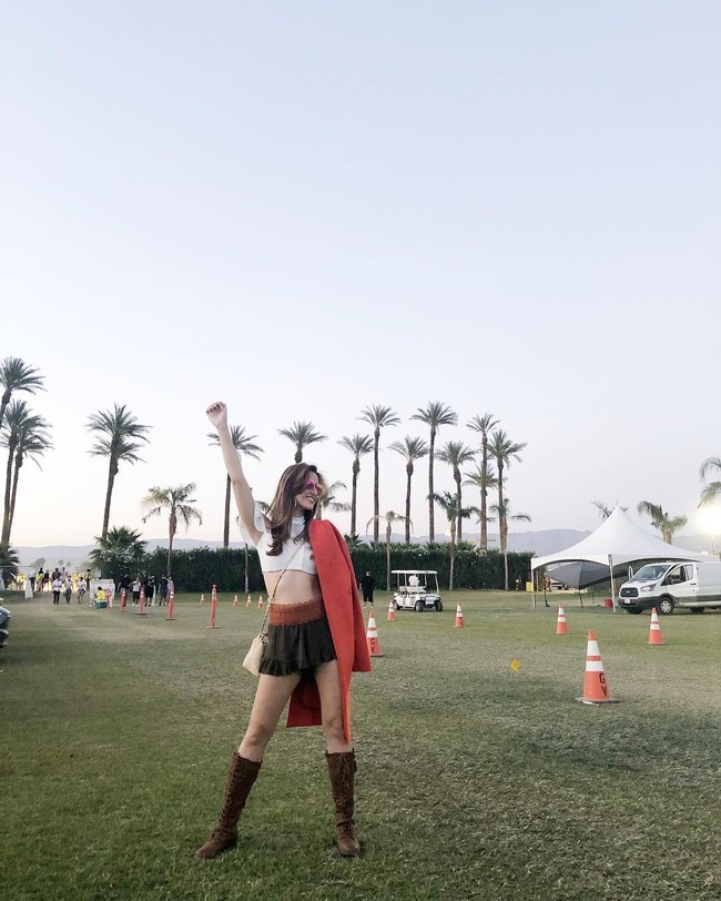 Atasan crop top kembali menjadi pilihan Nia Ramadhani saat menonton para musisi yang manggung di Coachella hari kedua, Sabtu (14/4/2018). Kali ini busana crop top putih itu dipadukannya dengan rok mini dan boots berwarna cokelat. Foto: Dok. Instagram Nia Ramadhani