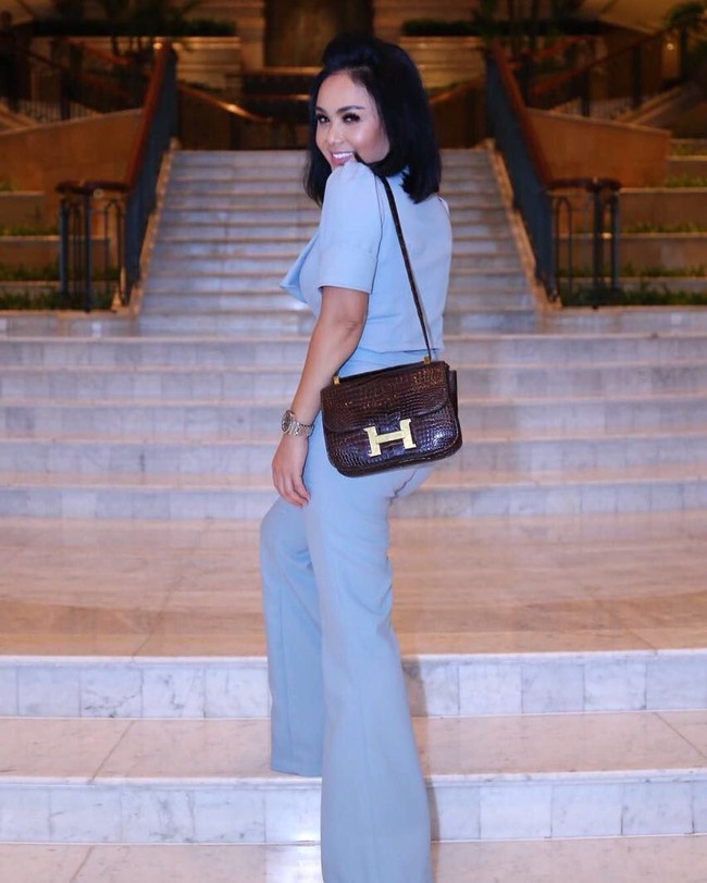 Tas Hermes Constance berwarna cokelat yang terbuat dari kulit buaya mempermanis gaya Yuni Shara yang tampil dengan baju serba biru. Tas Hermes berukuran kecil yang dibawa Yuni Shara ini harganya mencapai US$ 27.295 atau sekitar Rp 375, 8 juta. Foto: Instagram/yunishara36