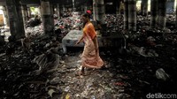 Seorang warga melintas diantara tumpukan sampah.