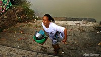 Warga meninggalkan Sungai Cisadane setelah selesai mencuci.