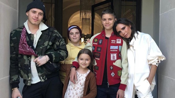 NEW YORK, NY - FEBRUARY 11: Designer Victoria Beckham embraces Romeo Beckham seated next to Harper Beckham, Cruz Beckham and David Beckham at the Victoria Beckham - fashion show February 2018 during New York Fashion Week on February 11, 2018 in New York City.  (Photo by JP Yim/Getty Images)