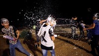 Mereka juga menyemprotkan foam spray kepada warga lainnya sebagai bentuk rasa gembira.