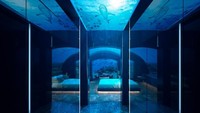 Foto: Traveler yang menginap di kamar underwater akan dihipnotis dengan nuansa biru yang terpantul dari pantulan air laut. Hanya dibatasi dengan kaca, traveler akan melihat langsung ikan-ikan berenang di sekeliling kamar. (dok conradmaldives)