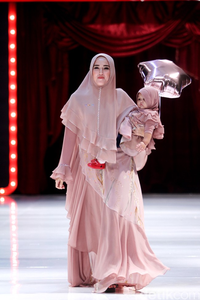 Istri Pasha Ungu, Adelia juga tampil cantik mengenakan busana koleksi Ti.Te.Ta. Ia melenggang di panggung runaway bersama sang buah hati. Foto: Mohammad Abduh/Wolipop