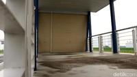 Pintu masuk halte masih tertutup rapat.
