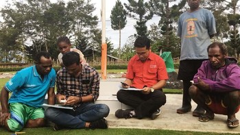 Petugas Telkomsel saat membantu pelanggan di Desa Wamaroma, Papua, untuk melakukan registrasi ulang kartu prabayar sesuai aturan yang telah ditetapkan pemerintah, (19/4).