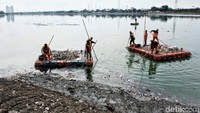 Sejumlah pekerja membersihkan sampah di Waduk Cincin, Kamis (19/4/2018).