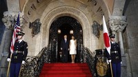 Tampak Donald Trump dan Abe memakai jas formal berwarna hitam. 