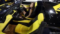 Seorang SPG berpose di dalam kabin mobil yang dipamerkan di IIMS 2018.