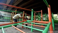 Seorang kakek tengah bermain bersama cucunya di arena bermain.
