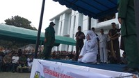 Usai M dieksekusi, petugas mengahadirkan NA menghadap algojo. Eksekusi terhadapnya sempat terhenti pada hitungan kelima karena NA mengangkat tangan ke atas tanda menyerah. Namun setelah diberi air mineral, cambuk dilanjutkan hingga hitungan ke-11.