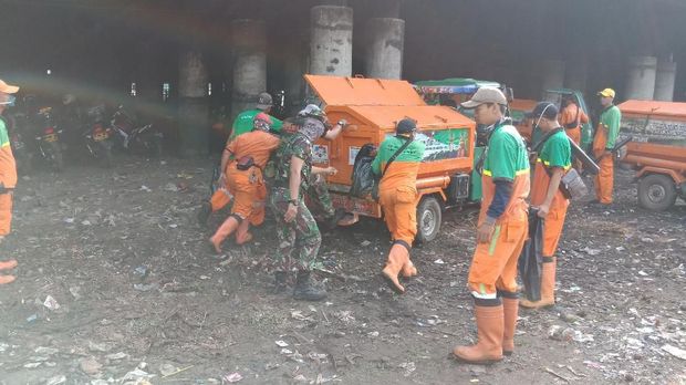 Petugas gabungan membersihkan sampah di kolong Tol Priok
