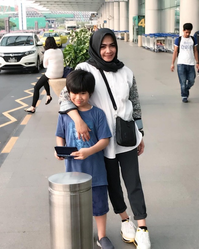 Rieta Amilia yang sudah bercerai dari ayah Nagita Slavina, Gideon Tengker memiliki seorang anak angkat Gavriel. Dia pun kerap berpergian bersama Gavriel. Seperti di foto ini saat jalan-jalan bersama Gavriel, Rita memakai tas Hermes seri Evelyne seharga US$ 1.600. Dia juga menghiasi kakinya dengan Leather Platform Sneakers Prada seharga US$ 750 atau sekitar Rp 10 jutaan. Foto: Instagram/rieta_amilia