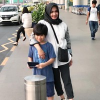 Rieta Amilia yang sudah bercerai dari ayah Nagita Slavina, Gideon Tengker memiliki seorang anak angkat Gavriel. Dia pun kerap berpergian bersama Gavriel. Seperti di foto ini saat jalan-jalan bersama Gavriel, Rita memakai tas Hermes seri Evelyne seharga US$ 1.600. Dia juga menghiasi kakinya dengan Leather Platform Sneakers Prada seharga US$ 750 atau sekitar Rp 10 jutaan. Foto: Instagram/rieta_amilia