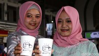 Dua pegawai PT KCI berbusana kebaya memamerkan kopi.