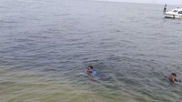 Sandiaga berenang dari titik kapal berhenti menuju dermaga Pulau Bidadari Sabtu (21/4/2018) sekitar pukul 15.00 WIB. Jaraknya sekitar 100 meter. Nampak, dua life guard pantai berjaga sambil berenang bersama Sandiaga.Fotografer: Mochammad Zhacky/detikcom