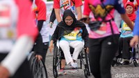 Para penyandang disabilitas ini terus mendorong kursi rodanya hingga ke garis finish.