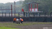 Petugas membantu mengangkut motor yang terjatuh dalam sesi latihan.