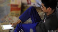 Engkus duduk sambil jari kaki kanan mengetik rangkaian kata di ponsel layar sentuh miliknya. Jari-jari kaki saya biasanya digunakan untuk mengetik. Saya benar-benar bersyukur kepada Allah karena memberikan jari-jari kaki yang berguna bagi saya, ujar Engkus. (Foto: Syahdan Alamsyah/detikcom).