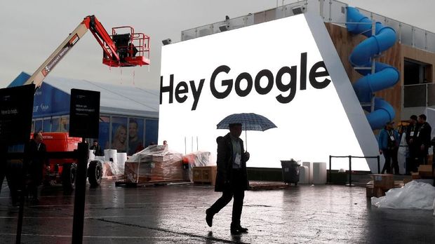 FILE PHOTO: A man walks through light rain in front of the Hey Google booth under construction at the Las Vegas Convention Center in preparation for the 2018 CES in Las Vegas, Nevada, U.S. January 8, 2018. REUTERS/Steve Marcus