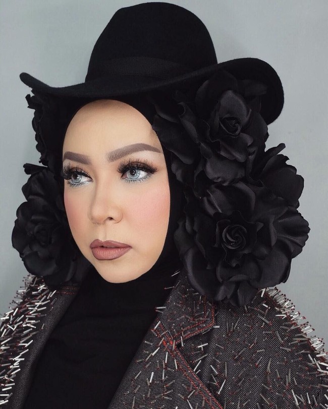 Tampil dengan jaket stud, penampilan Melly Goeslaw semakin unik dengan topi dan hiasan bunga berwarna hitam yang memenuhi bagian kiri dan kanan kepalanya. Foto: Instagram melly_goeslaw