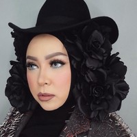 Tampil dengan jaket stud, penampilan Melly Goeslaw semakin unik dengan topi dan hiasan bunga berwarna hitam yang memenuhi bagian kiri dan kanan kepalanya. Foto: Instagram melly_goeslaw