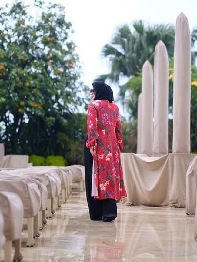 Kardigan panjang motif floral akan membuat pakaian serba hitam lebih semarak. Foto: Instagram/@queen_saritaabdulmukti
