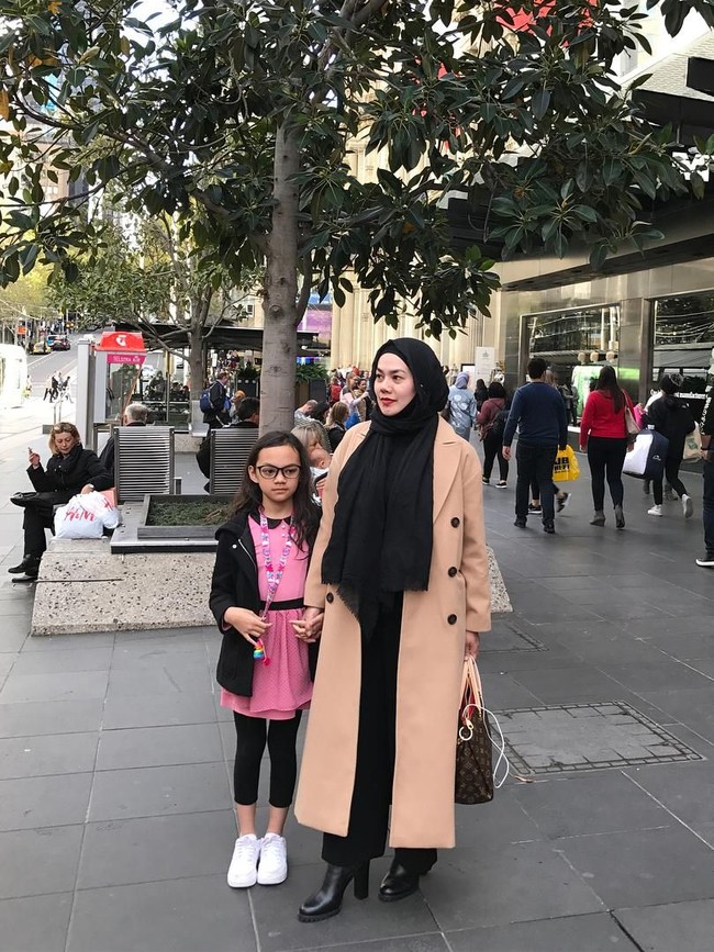Gaya Parisian Chic ala Sarita, pakai coat warna camel dipadu celana panjang hitam dan boots. Foto: Instagram/@queen_saritaabdulmukti
