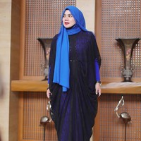 Sarita memadukan kaftan transparan berbahan lace dengan gaun panjang biru. Padu padan cerdas yang membuat pakaiannya tampak baru. Ia juga tampil cerah memakai jilbab biru muda yang senada dengan gaunnya. Foto: Instagram/@queen_saritaabdulmukti
