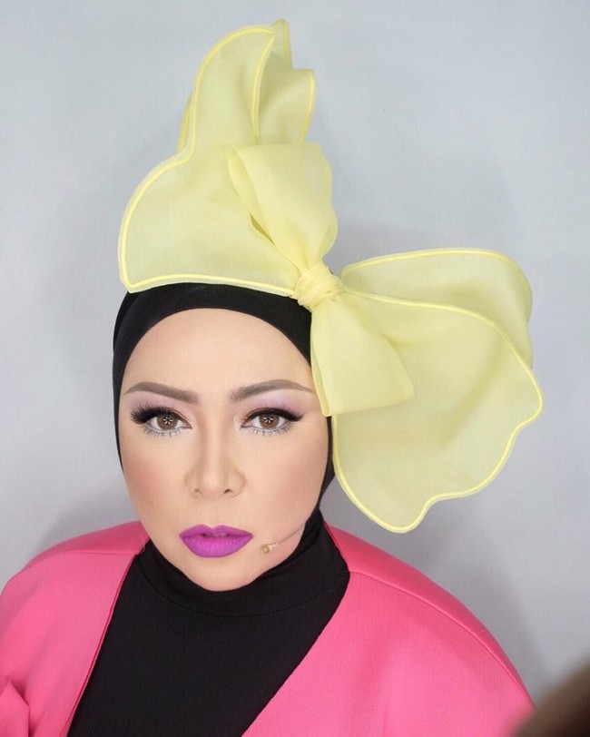 Memakai pita besar seperti telinga Mickey Mouse, penampilan Melly Goeslaw ini sungguh unik. Apalagi Melly memadukan warna-warna berbeda dalam satu tampilannya, mulai dari outer pink, lipstik ungu hingga pita besar berwarna kuning. Foto: Instagram melly_goeslaw