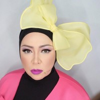 Memakai pita besar seperti telinga Mickey Mouse, penampilan Melly Goeslaw ini sungguh unik. Apalagi Melly memadukan warna-warna berbeda dalam satu tampilannya, mulai dari outer pink, lipstik ungu hingga pita besar berwarna kuning. Foto: Instagram melly_goeslaw