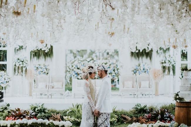 Walau di hutan, tapi konsep pelaminan dikemas seperti di gedung dengan backdrop mewah berhias bunga nuansa biru dan putih. Foto: Dok. Instagram/Nocture